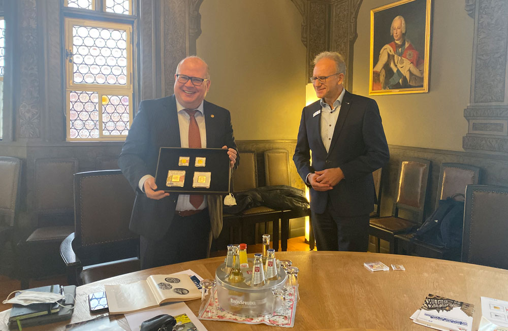 Helmut Euler (VR Bank Hessenland) überreicht Bürgermeister Stephan Paule den Jubiläumsbarren in Gold und Silber